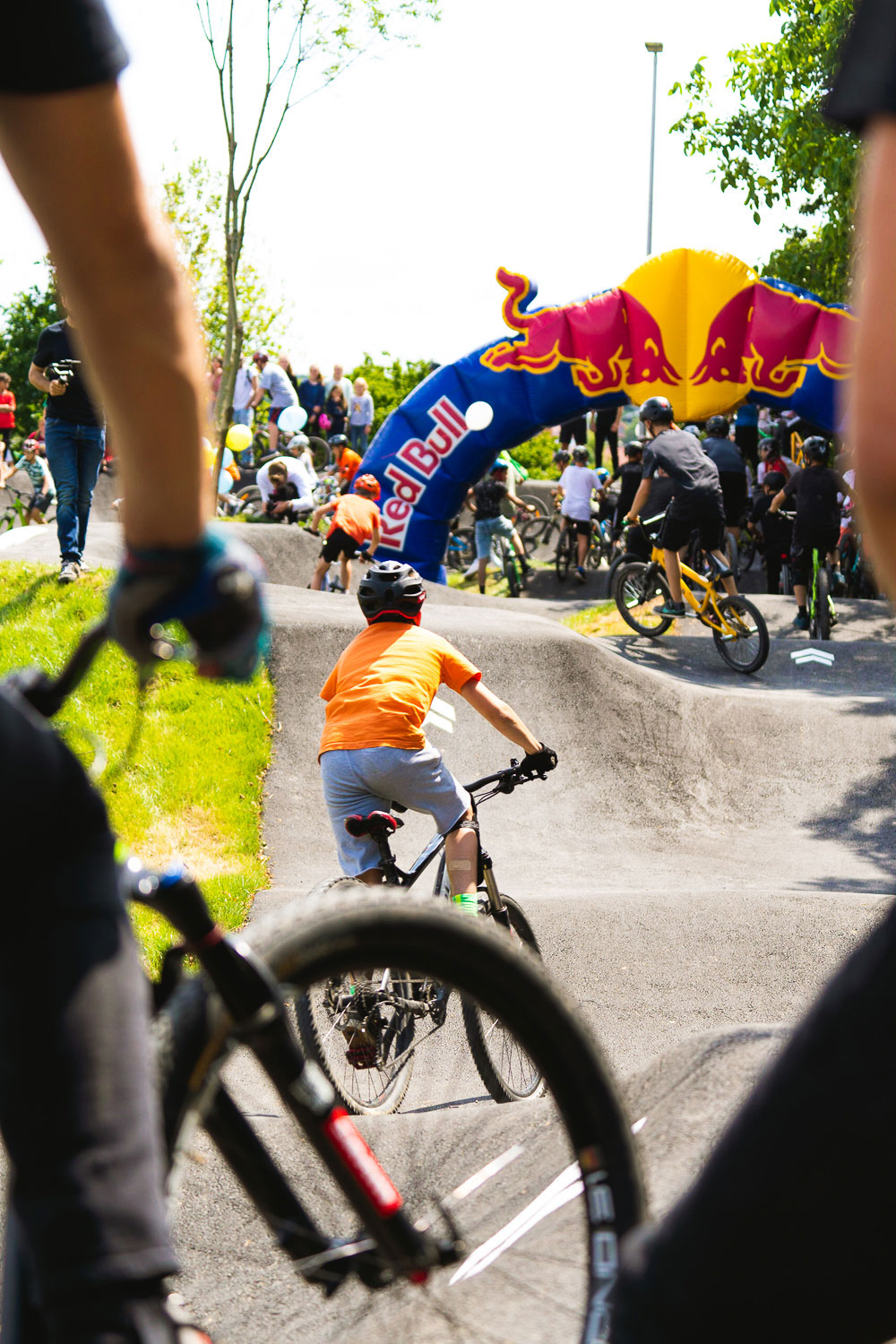 Jung und Alt fahren zusammen Mountainbike und Bmx auf der asphaltierten Pumptrack Bahn in Litzendorf. RadQuartier GmbH